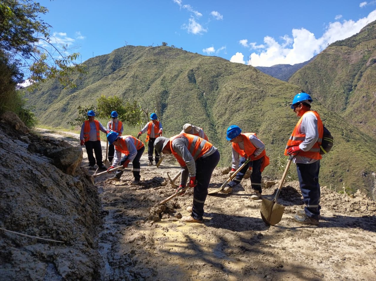 Personal trabajando en zona de carretera con montañas